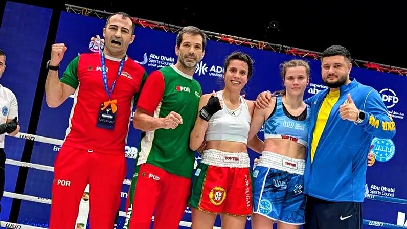 A nova campeã mundial de -60kg com os treinadores e a adversária