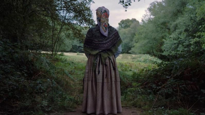 Mulher em traje tradicional galego posa num prado, simbolizando a ligação profunda da região à sua vegetação fértil e às chuvas que moldam a identidade natural da Galiza. 3 de Setembro de 2023, Curbián, Galiza, Espanha ©Carlos Folgoso Sueiro