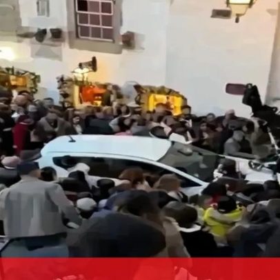 Carro tenta atravessar multidão em Castelo de Óbidos durante Vila de Natal