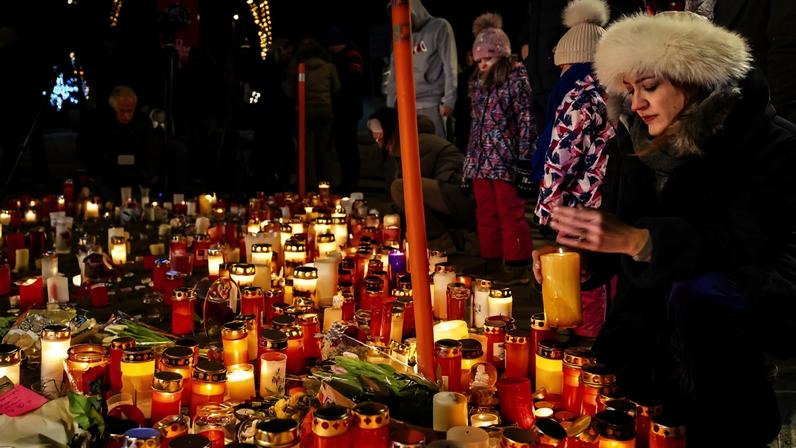 epaselect epa12621910 People pay their respects to the victims with flowers and candles near the area where a fire broke out during the New Year's celebrations in Crans-Montana, Switzerland, 02 January 2026. According to the police, several dozen people lost their lives in the fire that devastated the bar 'Le Constellation' on New Year's Eve in the Swiss Alps resort of Crans-Montana. Around one hundred people were also reported injured.