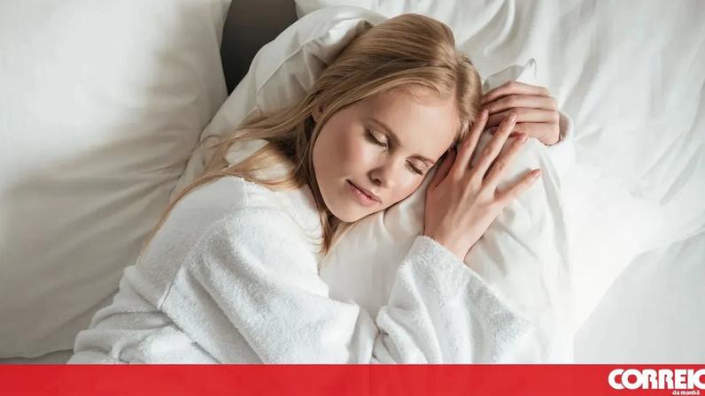 Mulher descansa num colchão Pikolin com roupa de cama e edredão