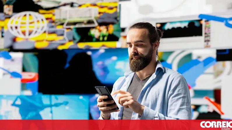 Homem utiliza smartphone com fundo de ecrãs diversos