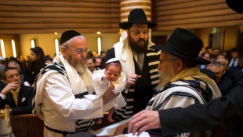 À esquerda, o mohel Manachem Fleischmann segura o bebé Mendl Teichtal após a circuncisão na sinagoga ortodoxa Chabad Lubawitsch, em Berlim, março 2013