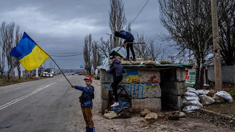 ARQUIVO - Crianças ucranianas brincam num posto de controlo abandonado em Kherson, no sul da Ucrânia, quarta-feira, 23 de novembro de 2022.