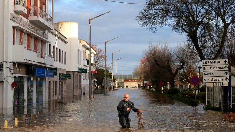 Polícias retiram moradores de um hotel de barco insuflável numa rua inundada, após a cheia do rio Sado devido a fortes chuvas em Alcácer do Sal