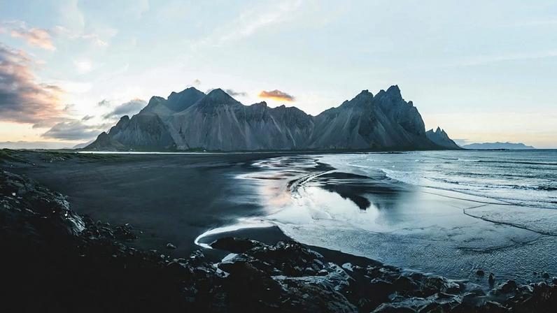 Paisagem montanhosa junto a uma massa de água na Islândia