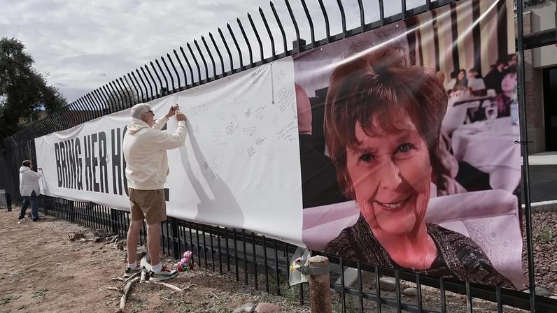 Jeff Robb, residente em Seattle e a passar o inverno em Tucson, assina uma faixa de apoio a Nancy Guthrie em Tucson, Arizona, na sexta-feira, 13 de fevereiro de 2026.