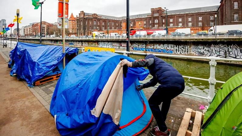 Shinwari, ex-capitão do exército afegão e requerente de asilo, fecha a sua tenda num acampamento improvisado no exterior do centro de acolhimento Petit Chateau, em Bruxelas, terça-feira, 31 de janeiro de 2023.