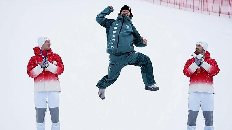 O brasileiro Lucas Pinheiro Braathen, ao centro, comemora a conquista da medalha de ouro no esqui alpino