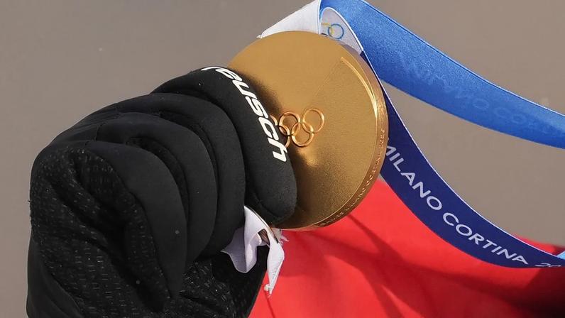 Alessandro Haemmerle, da Áustria, segura a sua medalha de ouro depois de vencer a final masculina de snowboard cross nos Jogos Olímpicos de inverno de 2026, em Livigno, Itália, quinta-feira, 12 de fevereiro de 2026.