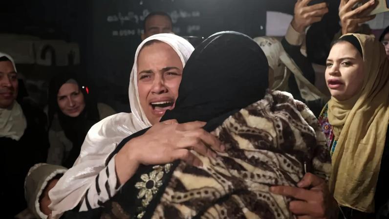 Mulheres palestinianas, vindas da passagem de Rafah com o Egito, abraçam-se à chegada ao Hospital Nasser, em Khan Younis, no sul da Faixa de Gaza