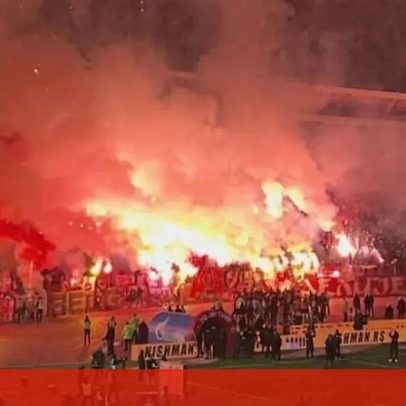 Adeptos do Partizan após derrota na casa da Estrela Vermelha; estádio em chamas