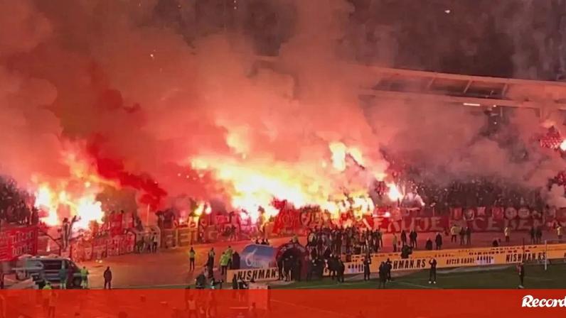 Adeptos do Partizan após derrota na casa da Estrela Vermelha; estádio em chamas