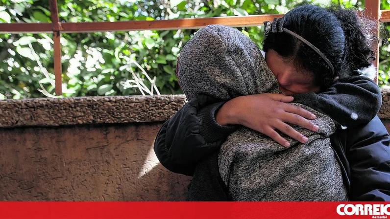 Uma mãe protege o filho dos ataques israelitas em Khan Younis, cidade do Sul do enclave palestiniano