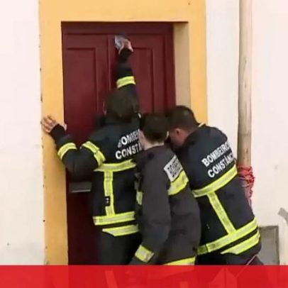 Bombeiro tenta abrir porta da casa inundada em Constância com ajuda de colegas