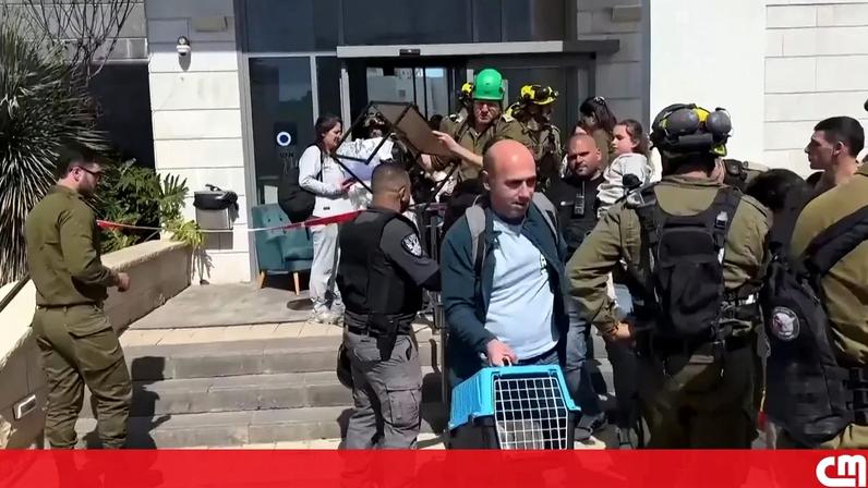 O momento em que famílias são retiradas de um edifício danificado após interceção de míssil iraniano em Israel