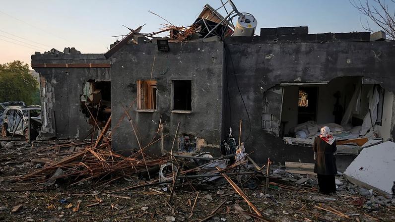 Mulher observa casa destruída por ataque de míssil iraniano em Zarzir, no norte de Israel