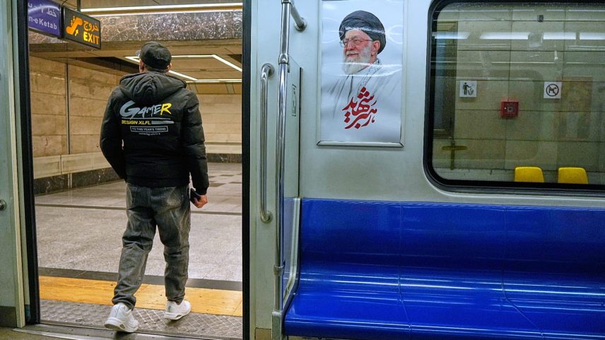 ARQUIVO: Um homem sai de um comboio do metro passando por uma imagem do falecido ayatollah iraniano Ali Khamenei, em Teerão, 13 de março de 2026