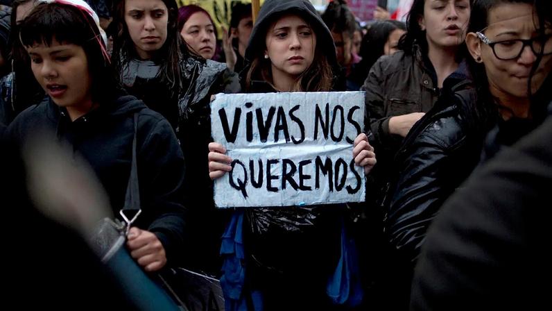 Uma mulher transporta um cartaz em espanhol com a frase «Queremo-nos vivas» durante uma manifestação contra a violência de género em Buenos Aires, Argentina, a 19 de outubro