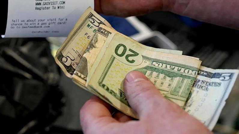 Um cliente tira o recibo num posto de combustível em Portland, Oregon, EUA, 16 de março de 2026