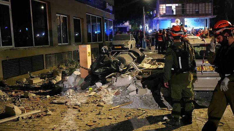 Forças de segurança israelitas inspeccionam o local de um ataque de míssil iraniano que matou duas pessoas em Ramat Gan, Israel, quarta-feira, 18 de março de 2026
