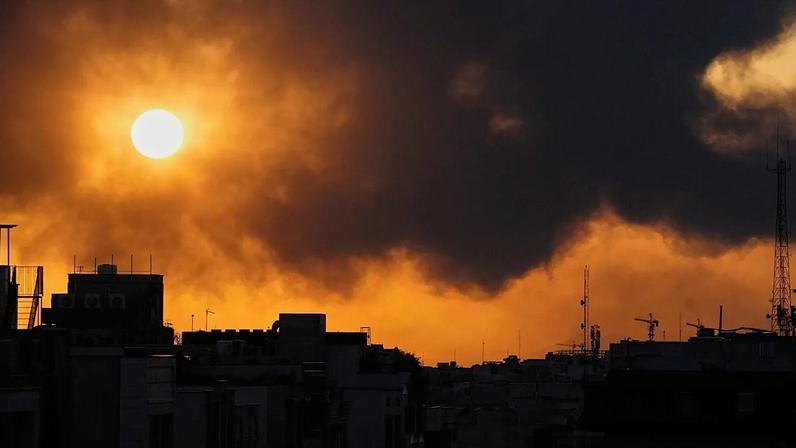 Pôr do sol atrás de uma coluna de fumo que se ergue após ataque militar dos EUA e de Israel em Teerão, Irão, terça-feira, 3 de março de 2026
