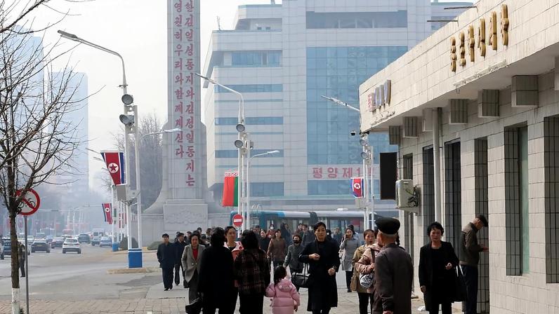Pessoas caminham numa rua do distrito central de Pyongyang, quarta-feira, 25 de março de 2026