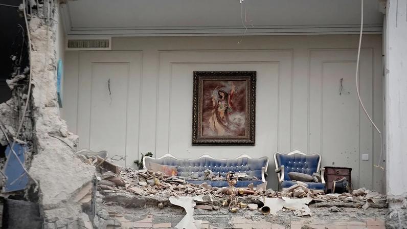 Os escombros cobrem os móveis de uma sala de estar destruída num edifício residencial atingido por um ataque israelo-americano em Teerão, Irão, segunda-feira, 23 de março de 2026.