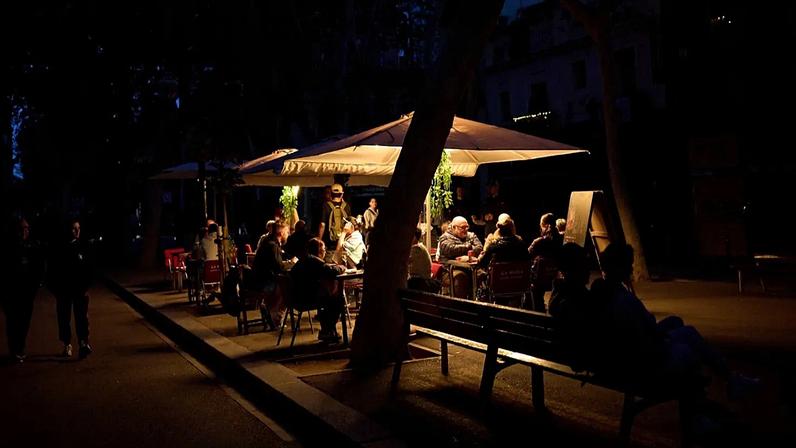 Clientes jantam num restaurante iluminado por um gerador durante um apagão em Barcelona, Espanha, segunda-feira, 28 de abril de 2025.