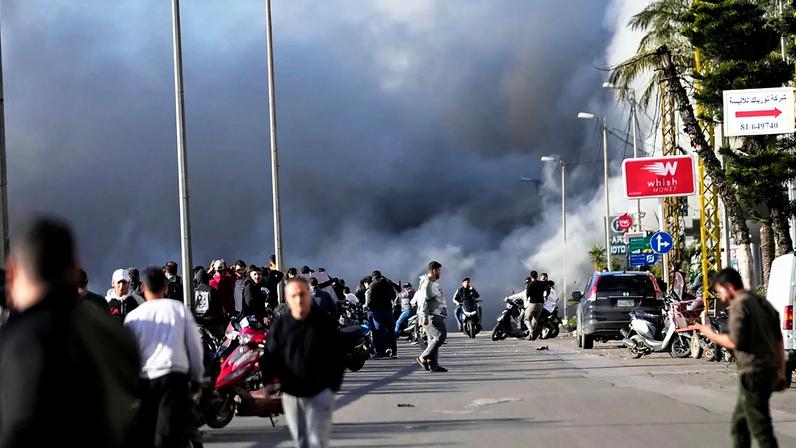 Fumo ergue-se enquanto transeuntes observam após um ataque israelita atingir um edifício junto à estrada do aeroporto em Beirute, Líbano, terça-feira, 31 de março de 2026.