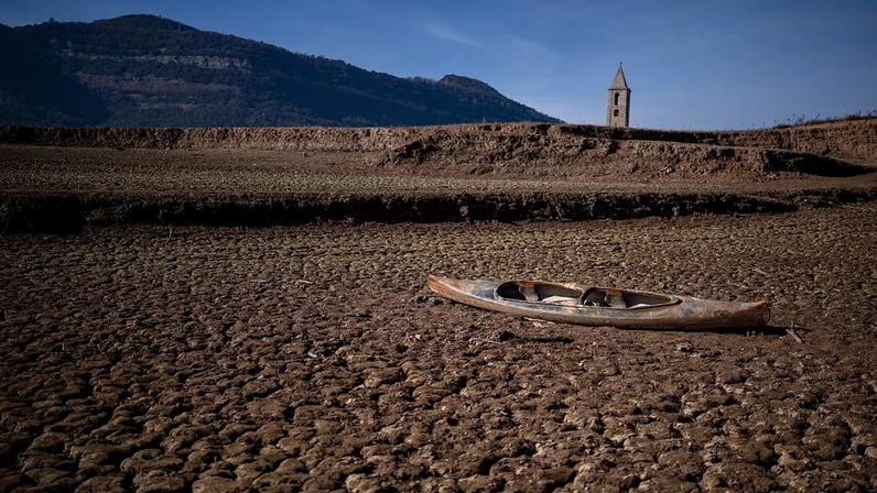 ARQUIVO - Uma canoa abandonada sobre o solo gretado durante a seca no reservatório de Sau, a norte de Barcelona, Espanha, segunda-feira, 22 de janeiro de 2024.