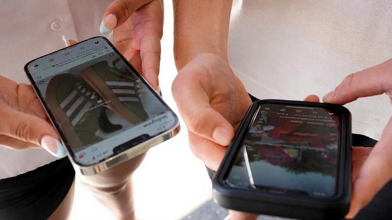 ARQUIVO - Jovens usam o telemóvel para ver redes sociais em Sydney, 8 de novembro de 2024
