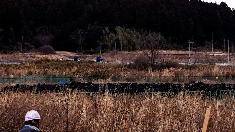 Sacos pretos com terra removida durante trabalhos de descontaminação estão empilhados em Okuma, na província de Fukushima, esta sexta-feira