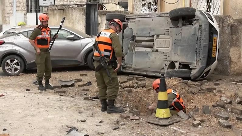 Moradores e equipas de emergência avaliam os estragos provocados pela queda de destroços de mísseis iranianos intercetados sobre Kfar Qassem, no centro de Israel