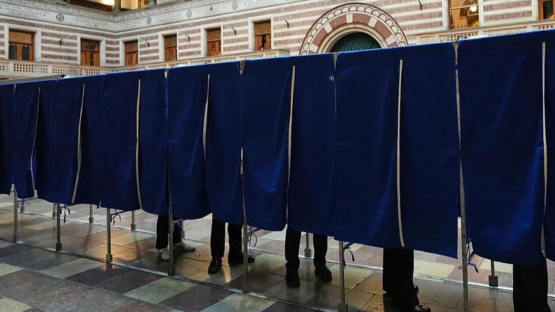 Pessoas votam numa mesa de voto na Câmara Municipal de Copenhaga, Dinamarca, na terça-feira, 24 de março de 2026, durante as eleições gerais.