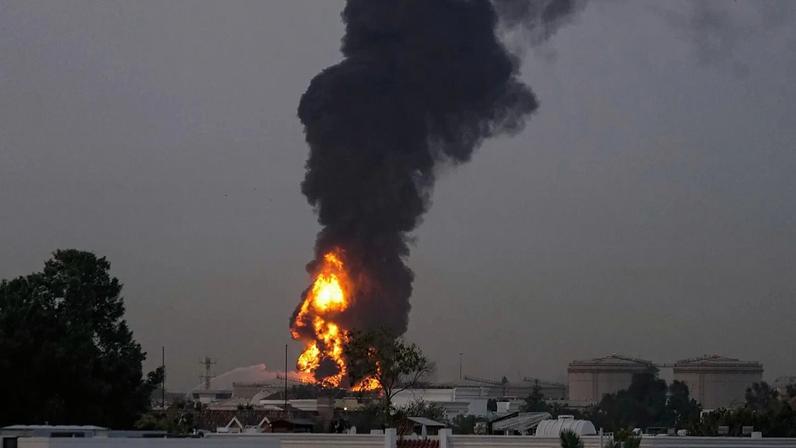 Fogo e nuvens de fumo surgem depois de um drone iraniano ter atingido um tanque de combustível, forçando a suspensão temporária dos voos. perto do Aeroporto Internacional do Dubai, 16 de março de 2026