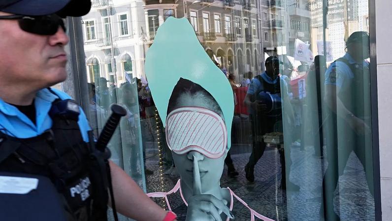 ARQUIVO (01.05.2023). Manifestantes e agentes da polícia refletem-se na janela de um hotel durante uma manifestação do Dia do Trabalhador em Lisboa, na segunda-feira
