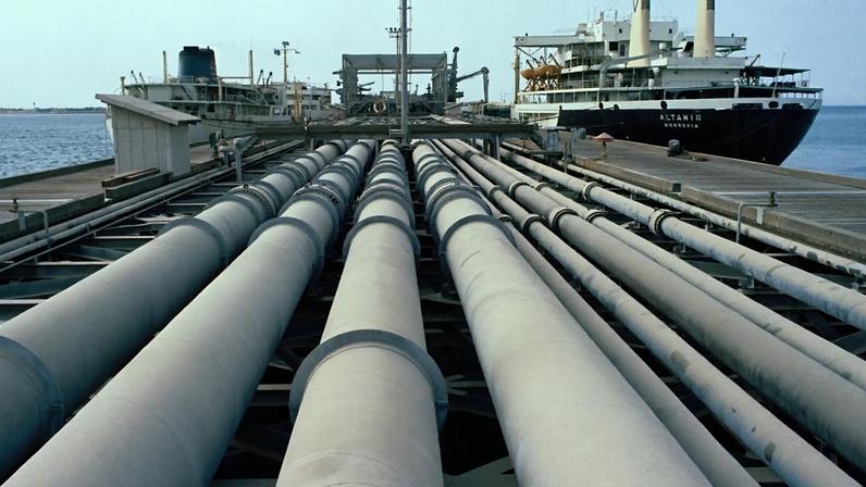 Fotografia de tubos de petróleo e de um navio-tanque no cais da ilha de Kharg, no Irão, o maior cais de petróleo do mundo, tirada em julho de 1971