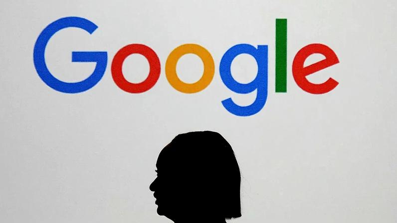 Uma mulher passa diante de um ecrã gigante com um logótipo, durante um evento no Google Lab de Paris, à margem da Cimeira de Ação para a IA, em 9 de fevereiro de 2025