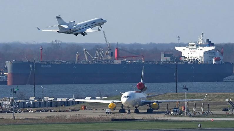 Um avião descola em vista de um petroleiro de crude no Aeroporto Internacional de Filadélfia, 26 de março de 2026