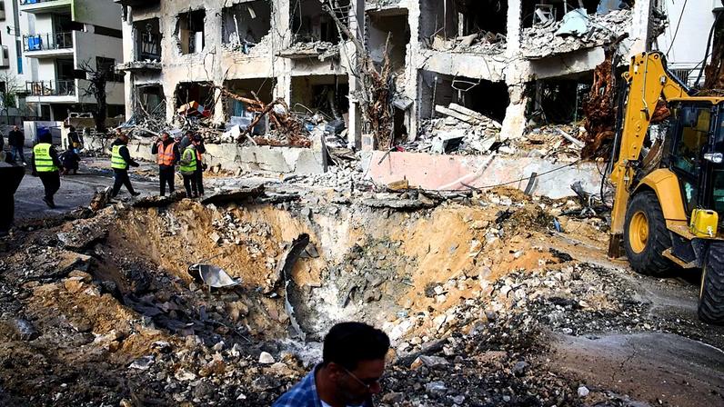 Equipas de salvamento e militares avaliam o local de um impacto direto um dia após um míssil iraniano atingir Telavive, Israel, domingo, 1 de março de 2026