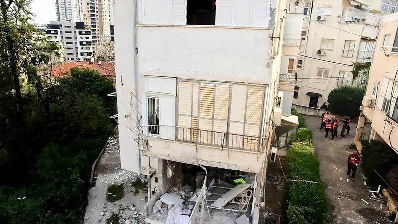 Um homem olha pela janela de um edifício de apartamentos que foi atingido por um míssil iraniano em Ramat Gan, Israel, quarta-feira, 18 de março de 2026. (AP Photo/Oded Balilty)