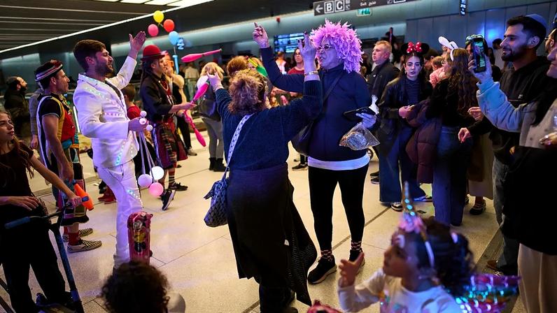 Pessoas, algumas mascaradas, celebram a festa judaica de Purim numa estação de metro usada como abrigo contra possíveis mísseis iranianos, em Ramat Gan