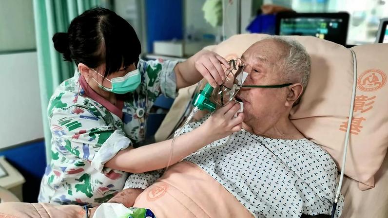 Enfermeira limpa a boca a um idoso internado