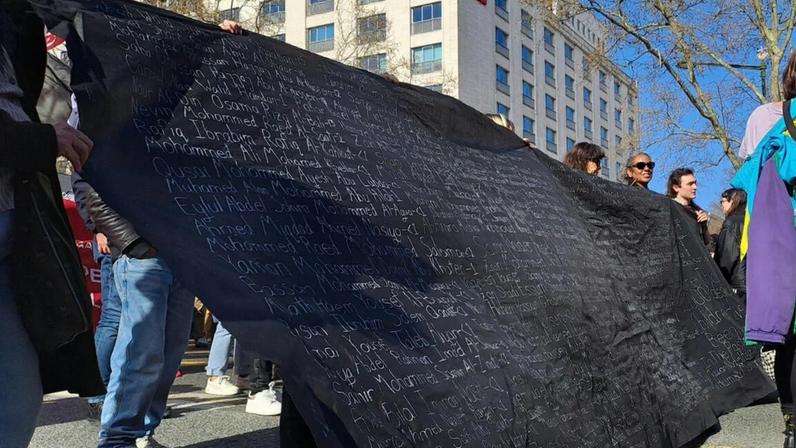 Manifestante segura faixa com nome das crianças mortas no ataque a uma escola, no Irão, no início desta semana (Foto: DR)