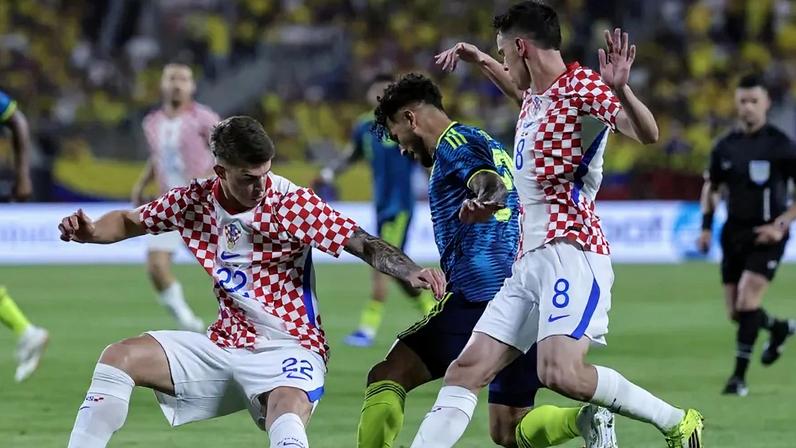 Luis Suárez tenta driblar dois adversários croatas