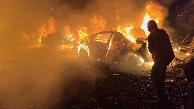 Um bombeiro apaga um carro no local dos ataques aéreos israelitas, em Beirute, no Líbano, quarta-feira, 1 de abril de 2026.