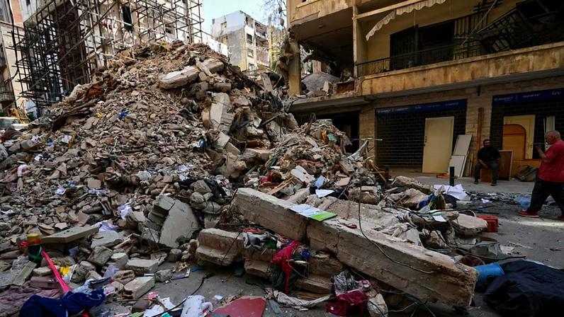 Moradores junto aos escombros de um edifício destruído que foi atingido há uma semana por um ataque aéreo israelita no centro de Beirute, Líbano, quinta-feira, 16 de abril de 2026