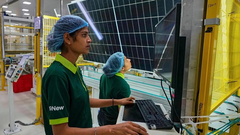 ARQUIVO - Trabalhadores verificam a qualidade de um painel solar na linha de produção de uma fábrica da ReNew nos arredores de Jaipur, Índia, 21 ago. 2025