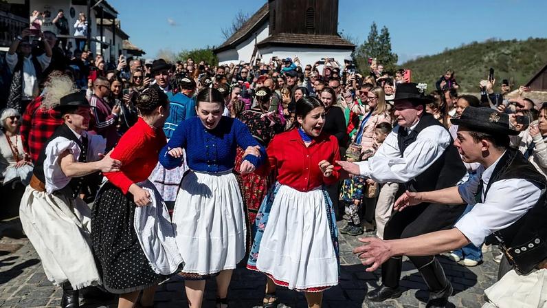 Rapazes e raparigas trajando roupa tradicional participam no festival popular da Páscoa na aldeia de Holloko, Património Mundial da UNESCO, no nordeste da Hungria